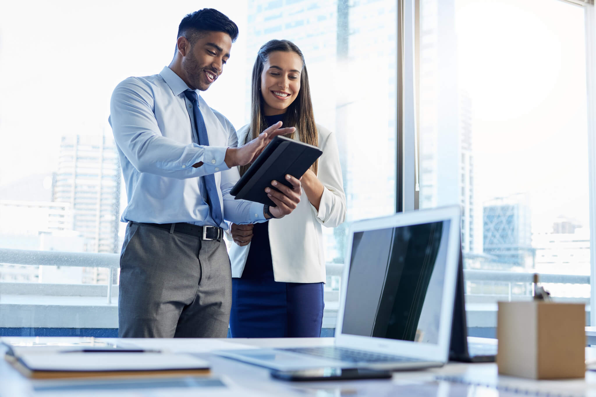 Shot of two businesspeople discussing something on a digital tablet