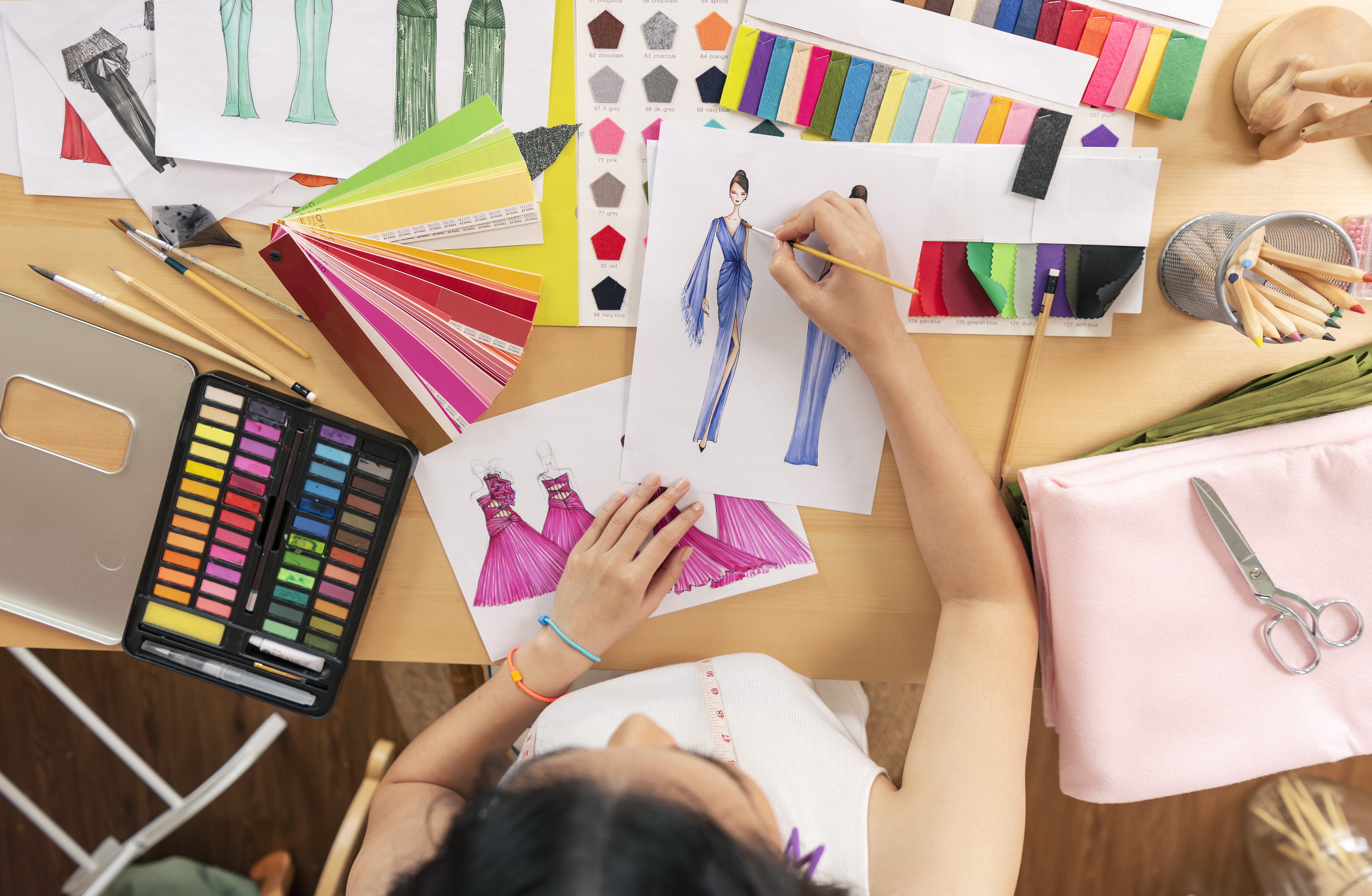 Beautiful asian Fashion designer drawing sketches for new collec