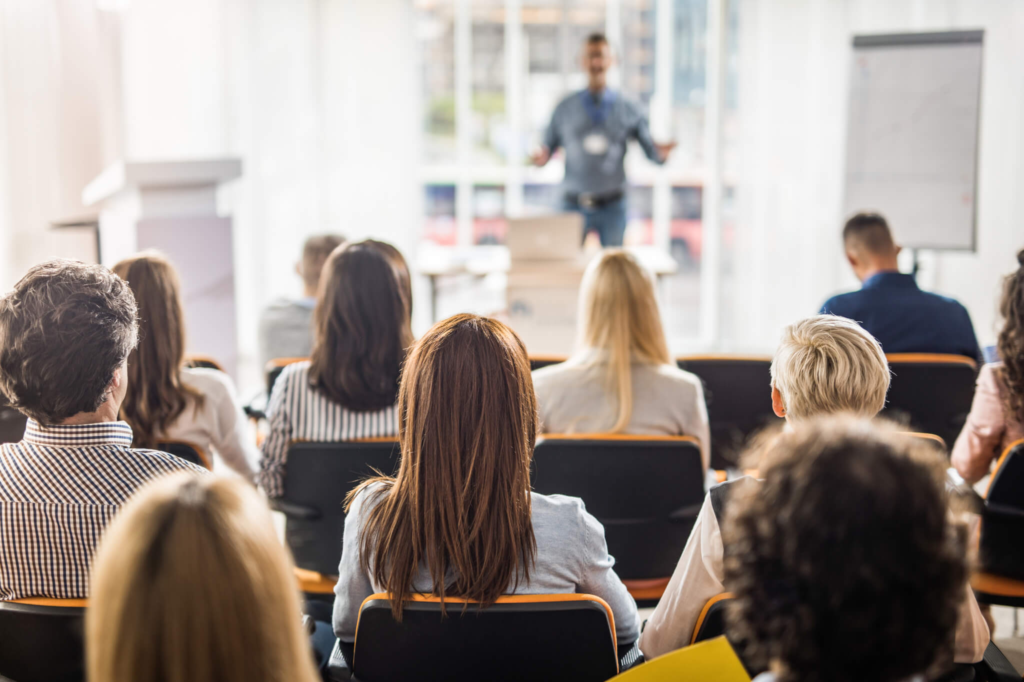 Rear view of business people attending a seminar in board room.