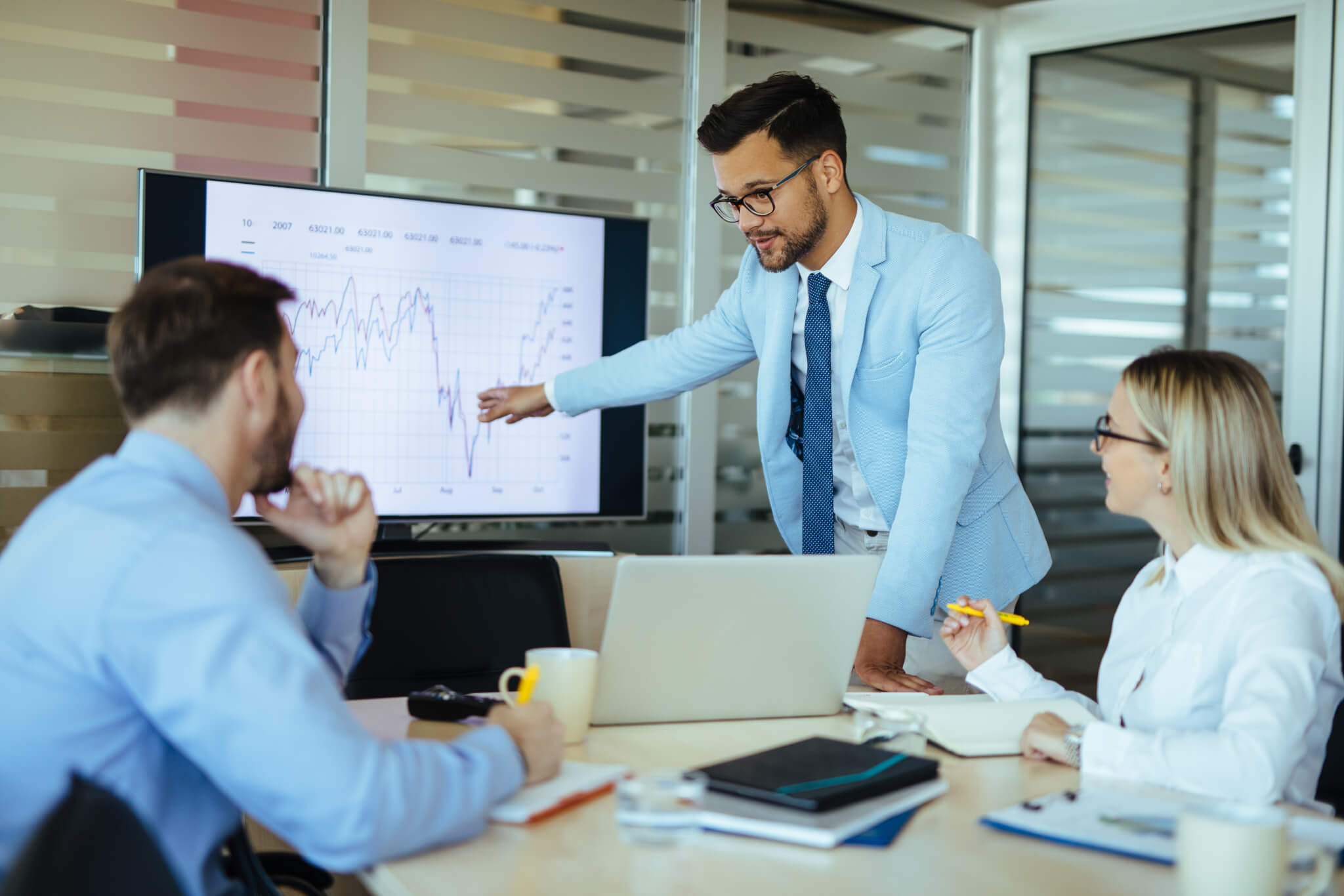 Young male executive leading presentation in meeting room