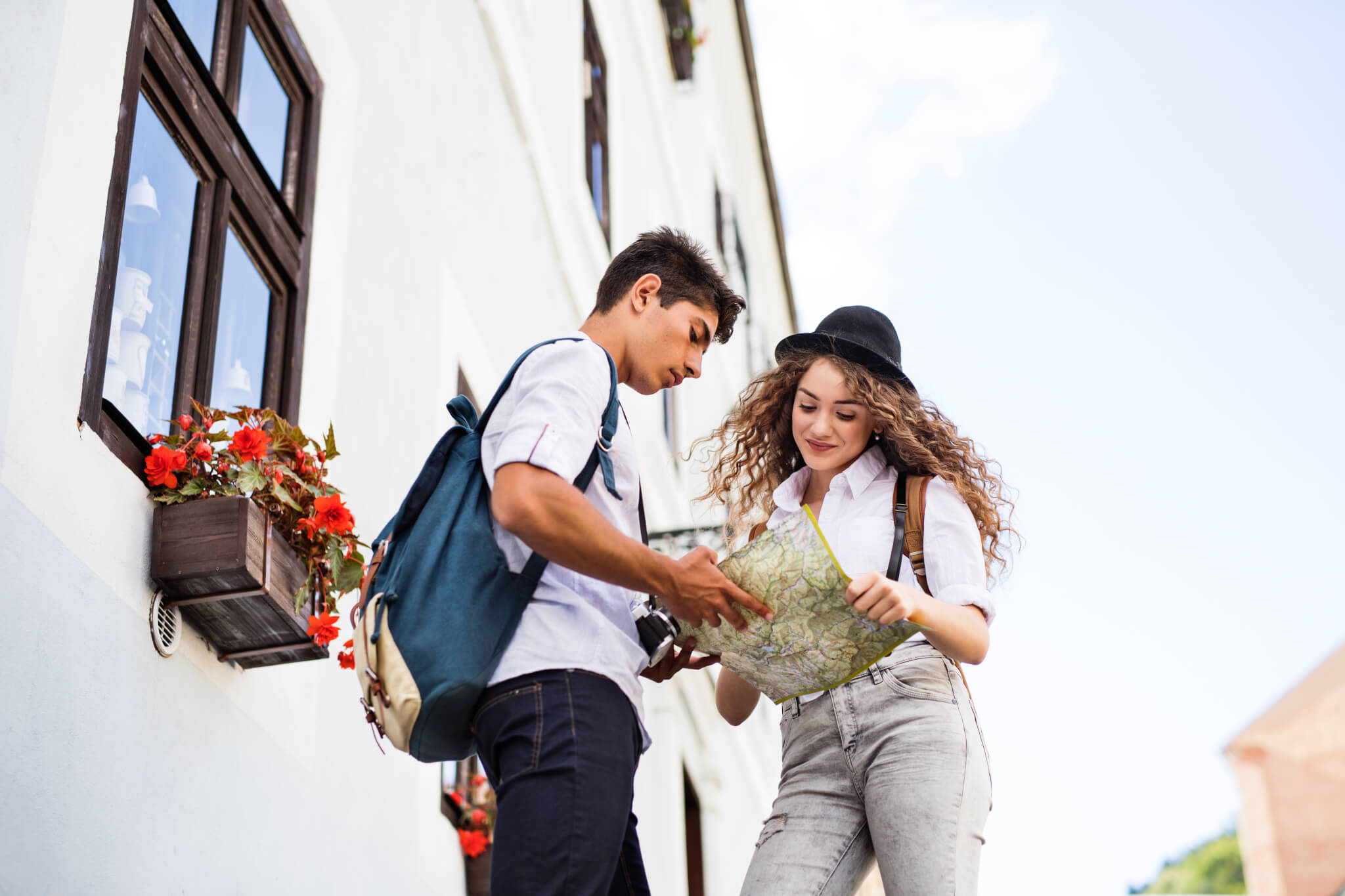 Two young tourists with map and camera in the old town