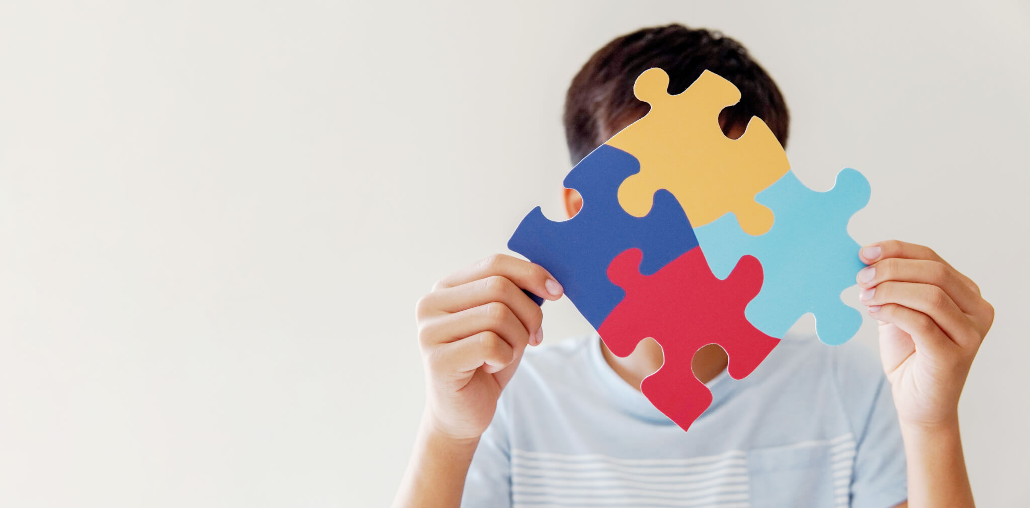 Kid boy hands holding puzzle jigsaw,  mental health concept, world autism awareness day